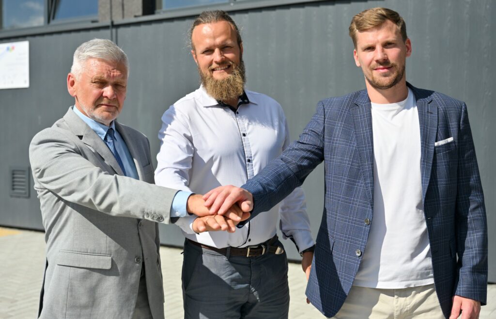 Three business professionals shaking hands outdoors, symbolizing collaboration and partnership. They are dressed in formal attire, with a modern building in the background, highlighting a professional setting. Three business professionals shaking hands outdoors, symbolizing collaboration and partnership. They are dressed in formal attire, with a modern building in the background, highlighting a professional setting.