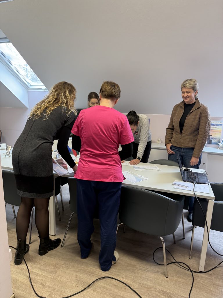 Group of professionals collaborating around a table in a bright, modern meeting room, discussing documents and planning.