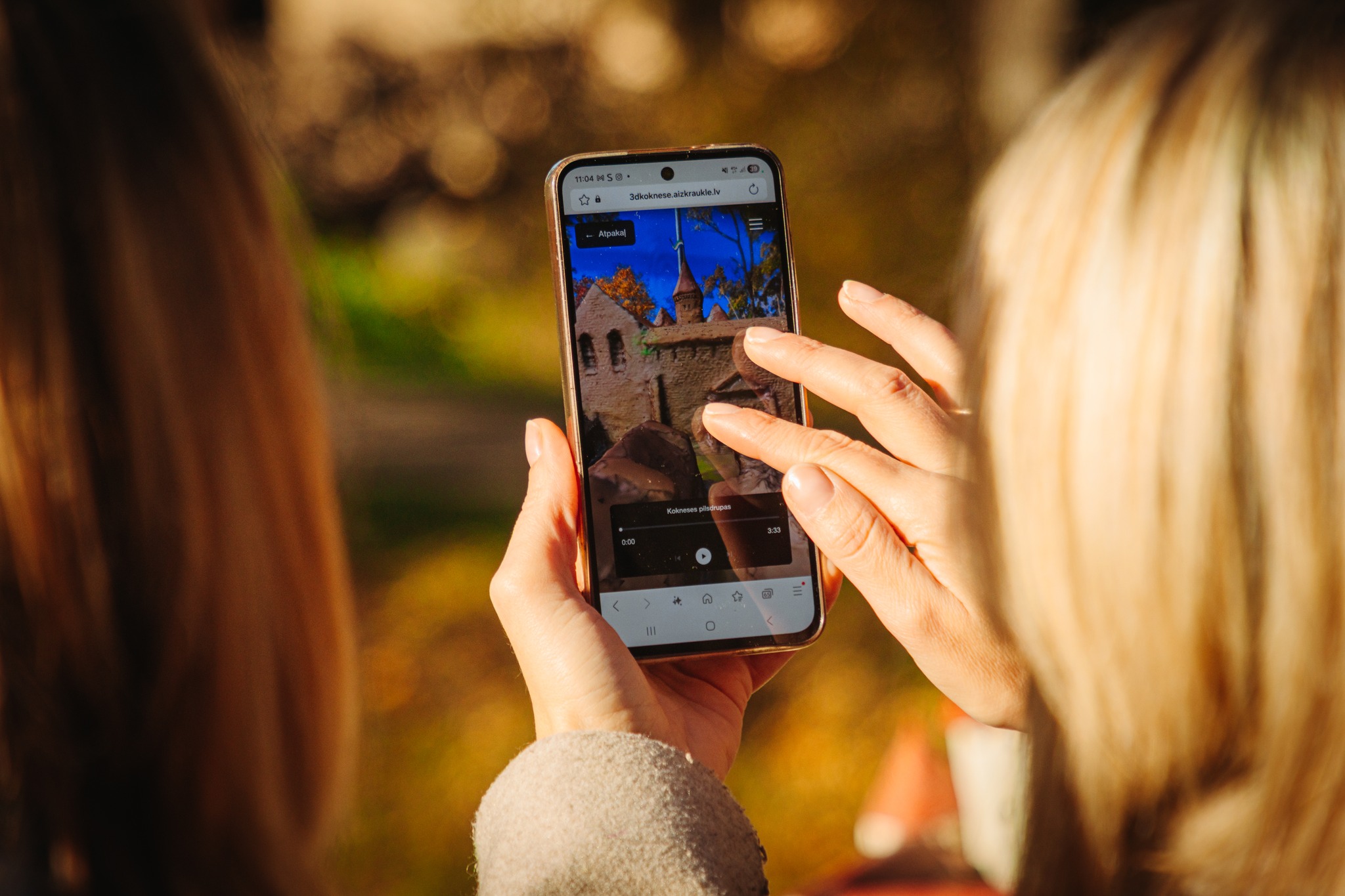 The person is holding a smartphone and touching the screen with fingers The person is holding a smartphone and touching the screen with fingers