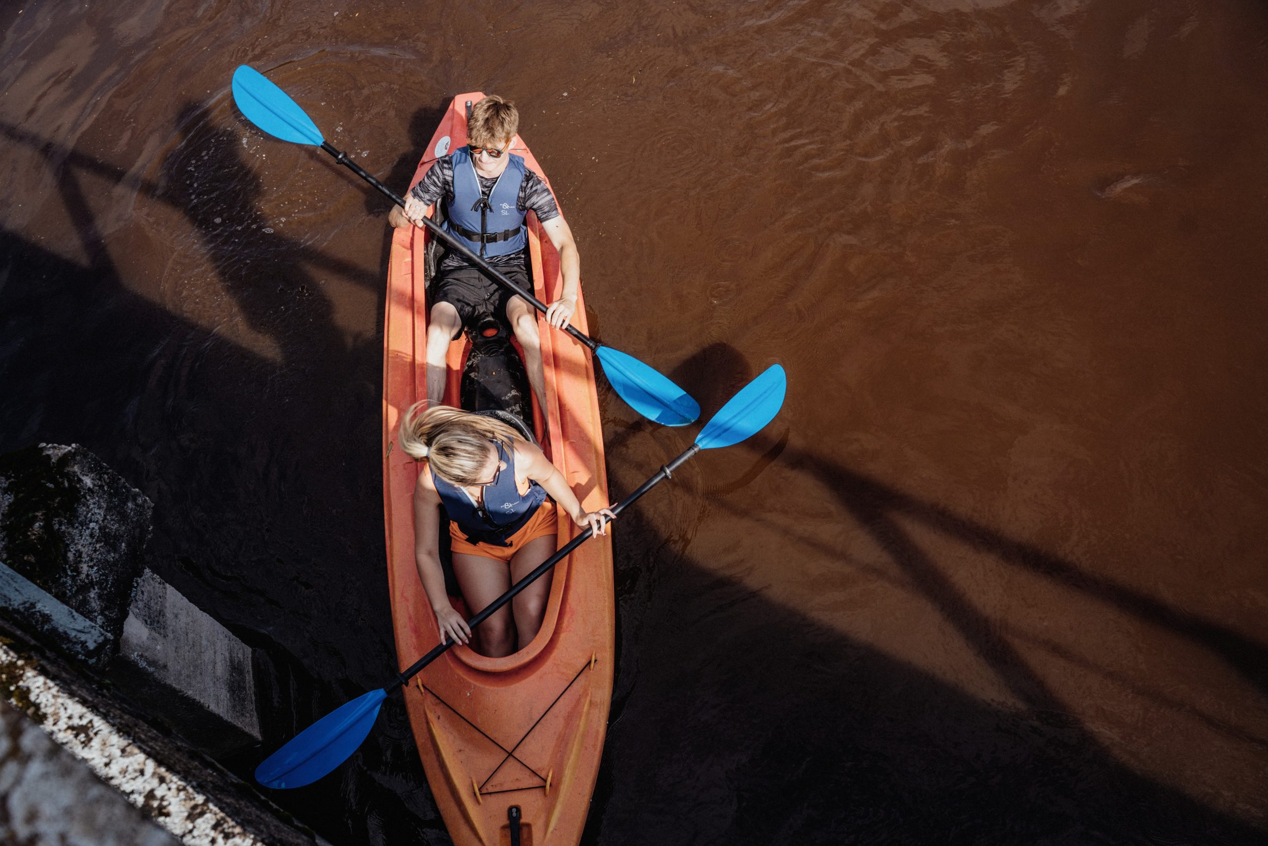 The canoe boat on the water with two people in it rowing The canoe boat on the water with two people in it rowing