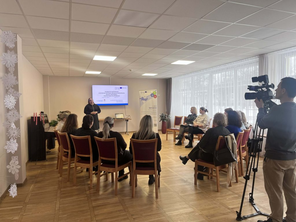 Group of professionals attending a presentation in a well-lit conference room, with a speaker at the front and a screen displaying information. Group of professionals attending a presentation in a well-lit conference room, with a speaker at the front and a screen displaying information.
