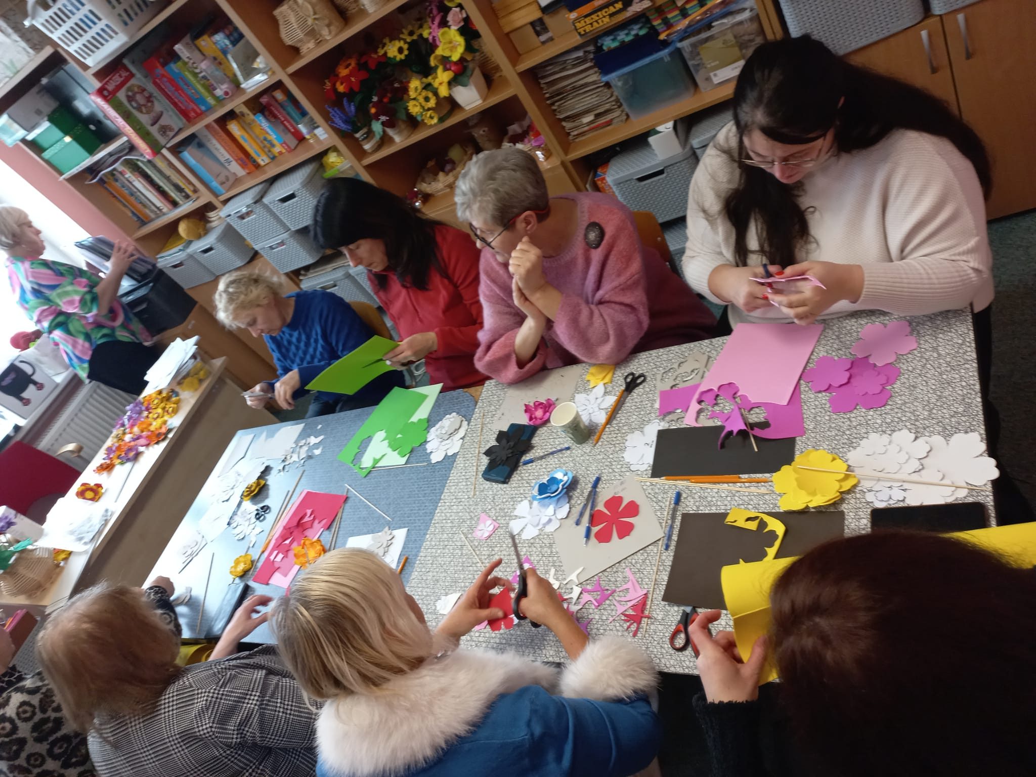 People sitting around the table in creative workshop with paper