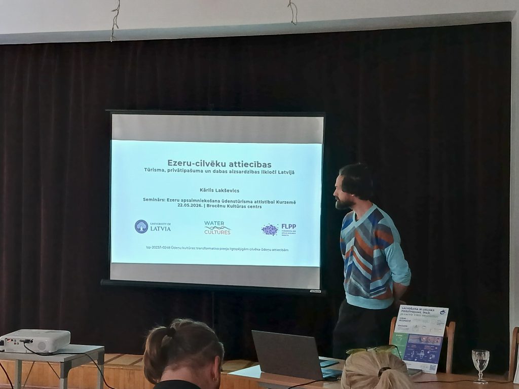 Speaker presenting at a seminar titled "Ezeru-cilvēku attiecības" focusing on tourism, sustainability, and nature conservation in Latvia, held at Brocēnu Kultūras centrs. The presentation includes contributions from the University of Latvia and Water Cultures. Speaker presenting at a seminar titled "Ezeru-cilvēku attiecības" focusing on tourism, sustainability, and nature conservation in Latvia, held at Brocēnu Kultūras centrs. The presentation includes contributions from the University of Latvia and Water Cultures.