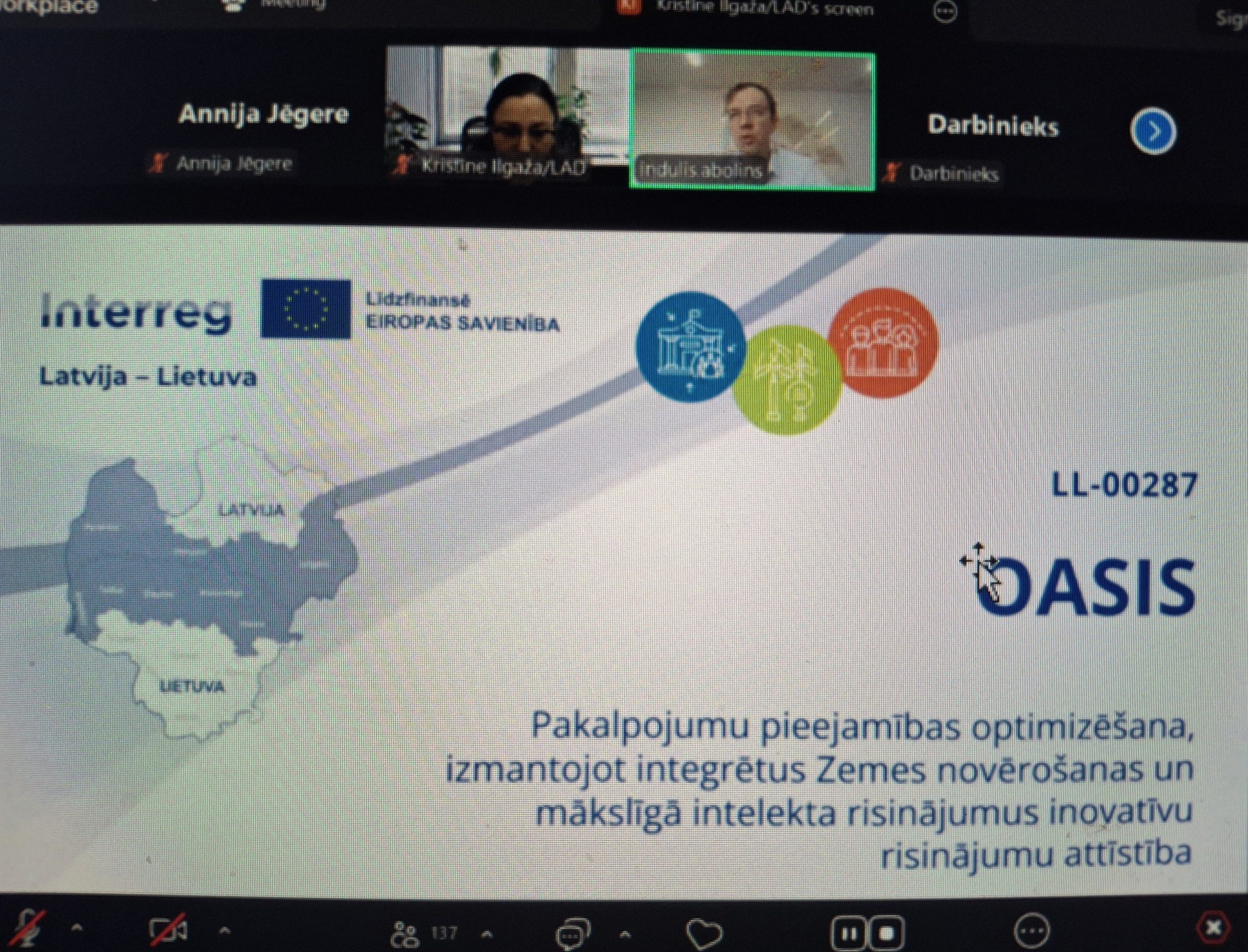 Image of a virtual meeting presentation titled "OASIS" under the Interreg program, featuring a map of Latvia and Lithuania. The slide discusses optimizing service accessibility using integrated land monitoring and innovative solutions for development. Participants are visible in the video conferencing interface.