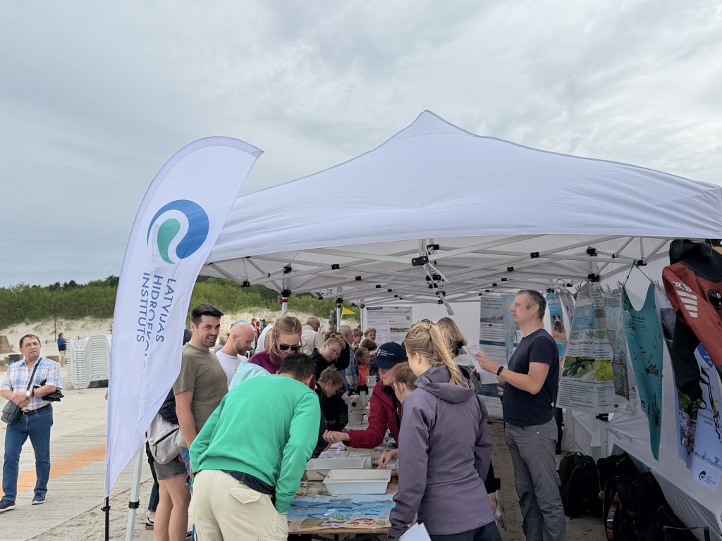 Crowd gathered at a tent for the Latvian Hydrographic Institute event, engaging with informational displays and activities related to marine research and conservation. Crowd gathered at a tent for the Latvian Hydrographic Institute event, engaging with informational displays and activities related to marine research and conservation.
