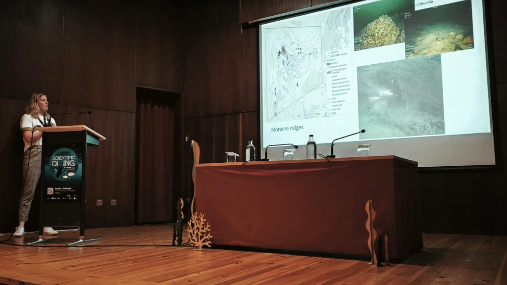 A researcher presents at a scientific conference in Azores, Portugal, discussing marine environments, with a focus on moraine ridges. The presentation includes a map and underwater images illustrating various sediment types.