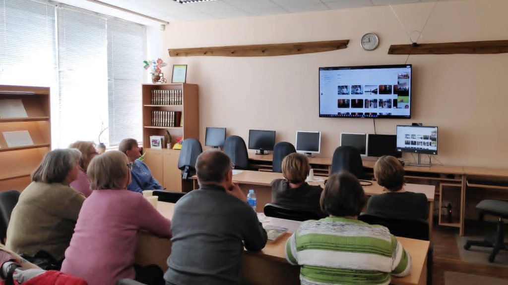 A group of adults attentively watching a presentation on a large screen in a classroom setting, with several computers visible in the background, highlighting the conclusion of the INCLUSIVE project and ongoing collaboration efforts. A group of adults attentively watching a presentation on a large screen in a classroom setting, with several computers visible in the background, highlighting the conclusion of the INCLUSIVE project and ongoing collaboration efforts.