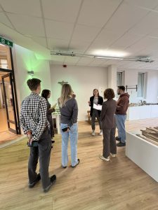 Group of museum professionals discussing the MATOMI project in a modern exhibition space, focusing on enhancing visitor experiences.