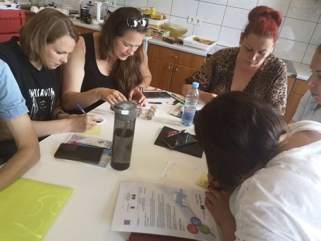 Participants engaging in a collaborative workshop, focused on educational strategies related to the Green Stories Project, surrounded by notebooks, pens, and educational materials on a table. Participants engaging in a collaborative workshop, focused on educational strategies related to the Green Stories Project, surrounded by notebooks, pens, and educational materials on a table.