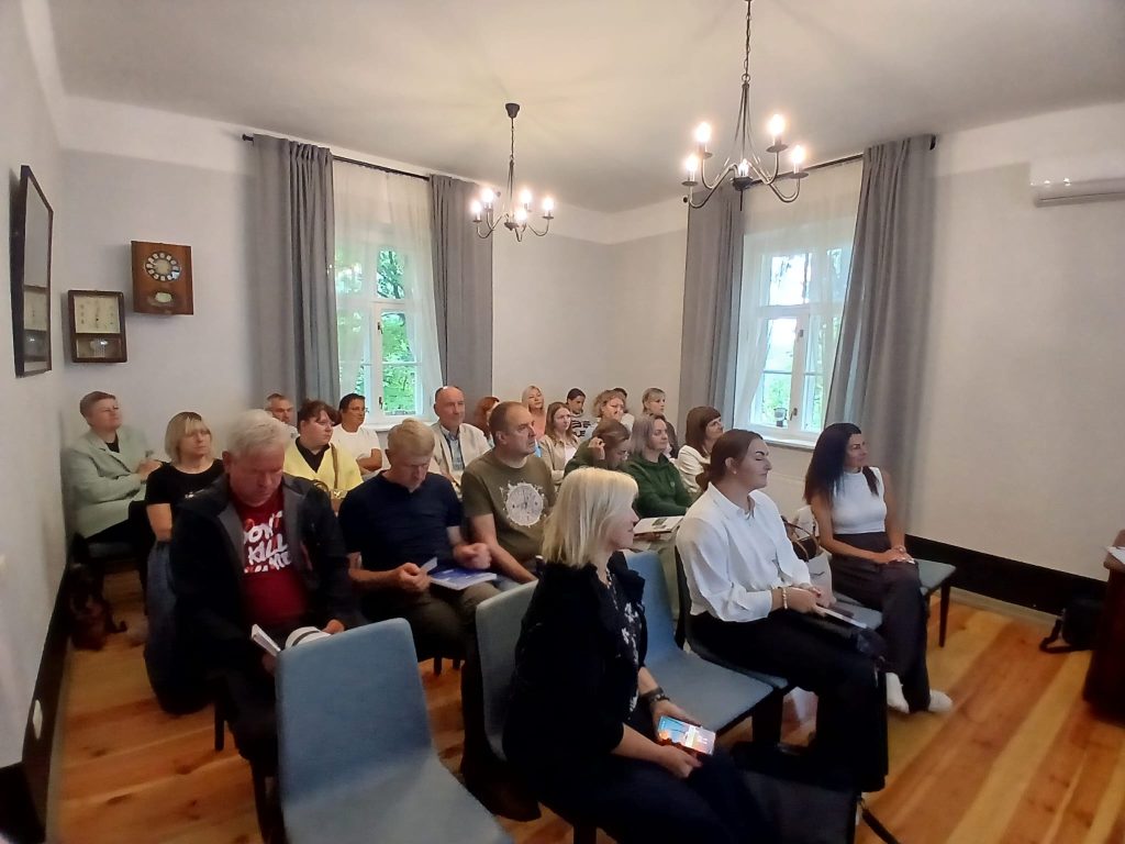 Audience engaged in a seminar about water tourism trends in Latgale at Lielborne Manor, seated in a well-lit room with large windows and decorative wall elements.
