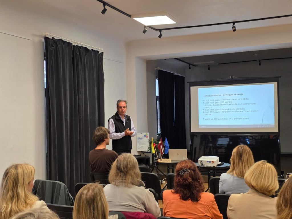 Presentation at the seminar in Saldus on the Geosites database, featuring Andris Grinbergs, a geology expert, discussing its practical applications to an engaged audience.