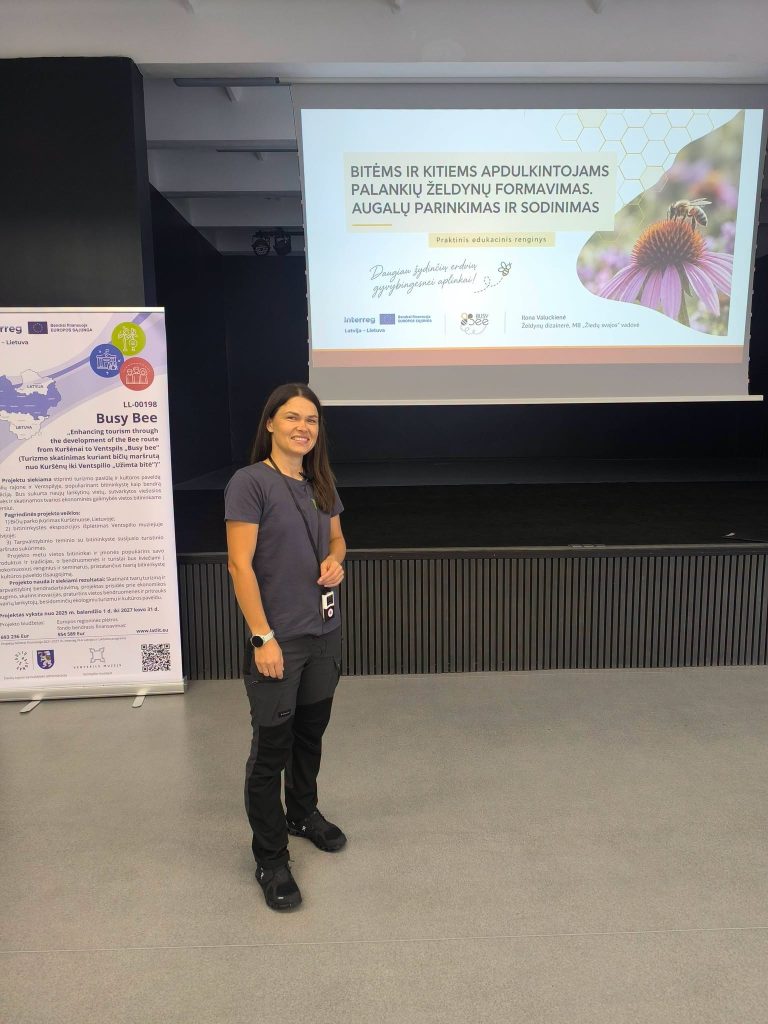 A speaker presenting at a workshop on creating bee-friendly gardens in a youth garden, with a presentation slide featuring a bee and flowers in the background.