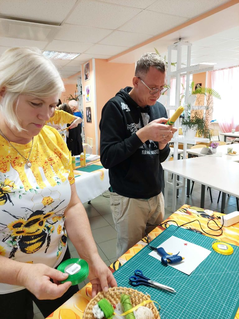 Participants engage in a creative workshop at the SoCreative Project meeting in Latvia, focusing on crafting with various materials. One individual prepares supplies while another works with a crafting tool, showcasing collaboration and artistic expression in a vibrant setting. Participants engage in a creative workshop at the SoCreative Project meeting in Latvia, focusing on crafting with various materials. One individual prepares supplies while another works with a crafting tool, showcasing collaboration and artistic expression in a vibrant setting.