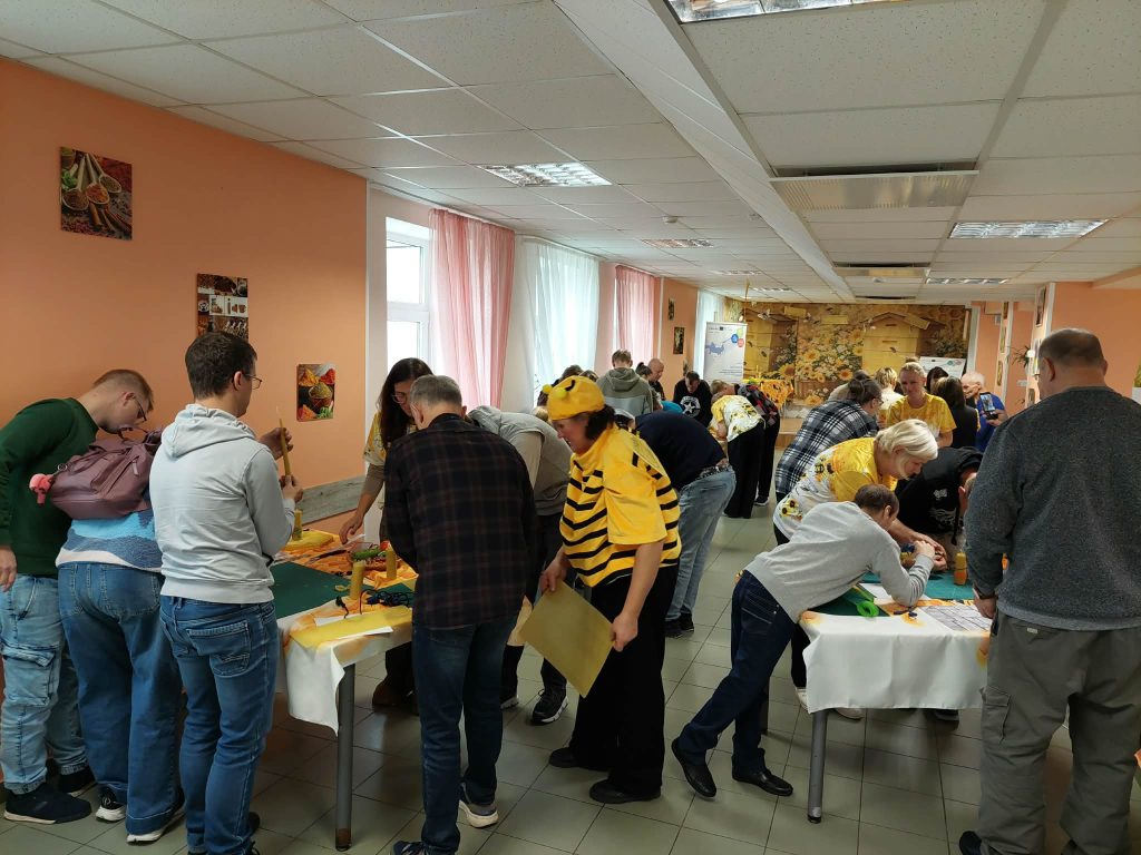 Participants engaged in creative activities during the SoCreative Project Meeting in Latvia, wearing bee-themed attire and collaborating at tables filled with art supplies. The event emphasizes creativity and togetherness in a vibrant, communal setting. Participants engaged in creative activities during the SoCreative Project Meeting in Latvia, wearing bee-themed attire and collaborating at tables filled with art supplies. The event emphasizes creativity and togetherness in a vibrant, communal setting.