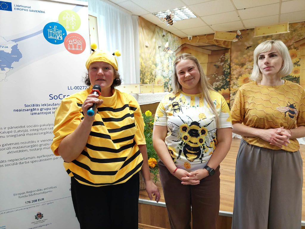 Three women dressed in bee-themed attire stand together at the SoCreative Project meeting in Latvia, promoting creativity and collaboration. The backdrop features a colorful banner and decorations related to bees, emphasizing the theme of togetherness in community projects. Three women dressed in bee-themed attire stand together at the SoCreative Project meeting in Latvia, promoting creativity and collaboration. The backdrop features a colorful banner and decorations related to bees, emphasizing the theme of togetherness in community projects.