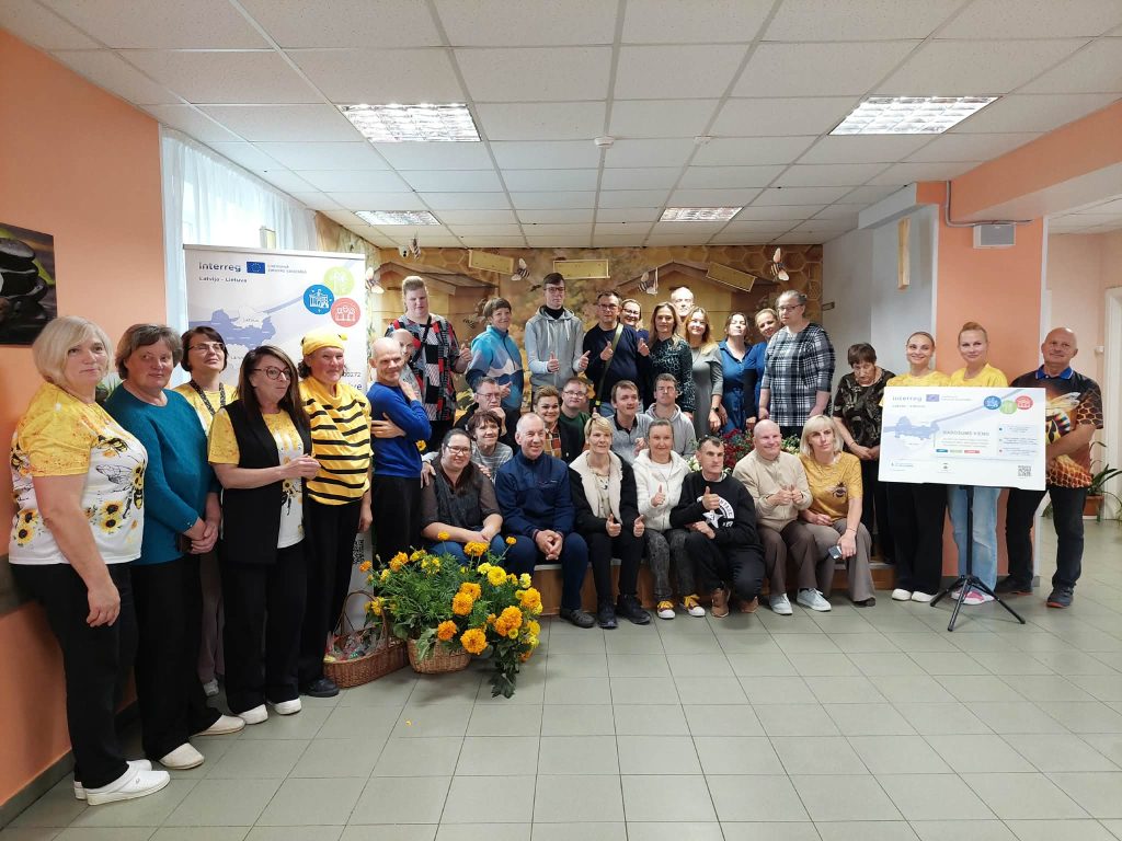 Group photo of participants at the SoCreative Project Meeting in Latvia, showcasing collaboration and creativity. The image features diverse individuals standing together, smiling, and holding a project banner, with a backdrop of floral arrangements and a warm, welcoming environment. Group photo of participants at the SoCreative Project Meeting in Latvia, showcasing collaboration and creativity. The image features diverse individuals standing together, smiling, and holding a project banner, with a backdrop of floral arrangements and a warm, welcoming environment.
