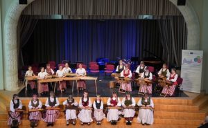 Traditional music performance at Interreg Cooperation Day, featuring musicians in cultural attire playing string instruments on stage, highlighting the themes of cooperation and cultural exchange.